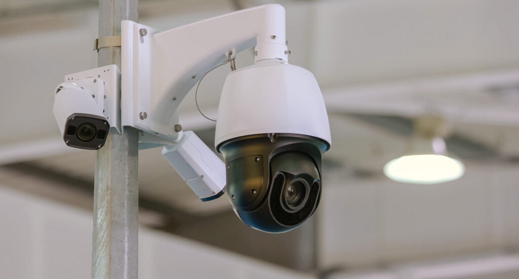 Rotating black surveillance control camera indoors. Public safety concept.